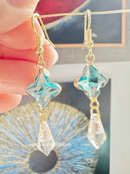 Celestial collection. One of a kind earrings, they can't be duplicated.  Designed and handmade by Marianna Mills.  Size: just a little over 2 inches  Teal blue glass star with metal outlining and clear crystal drop.