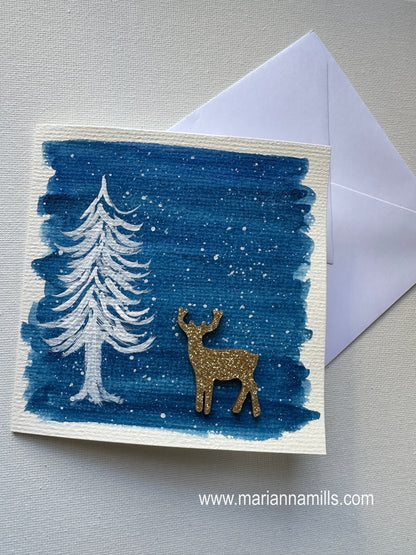 Hand painted Christmas Card #4 Snowy land with a white fir tree and glittery wood reindeer embellishment.